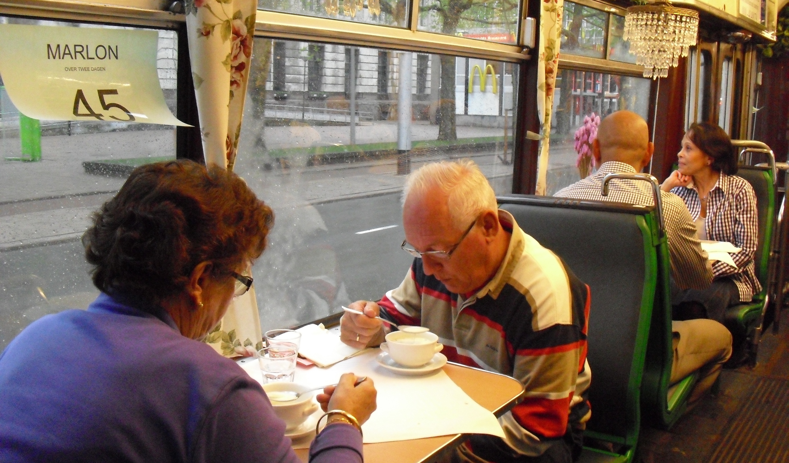Al dinerend in de tram dwars door donker Rotterdam